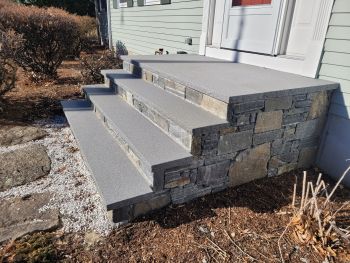 Masonry front steps with stone veneer leading to a house entrance